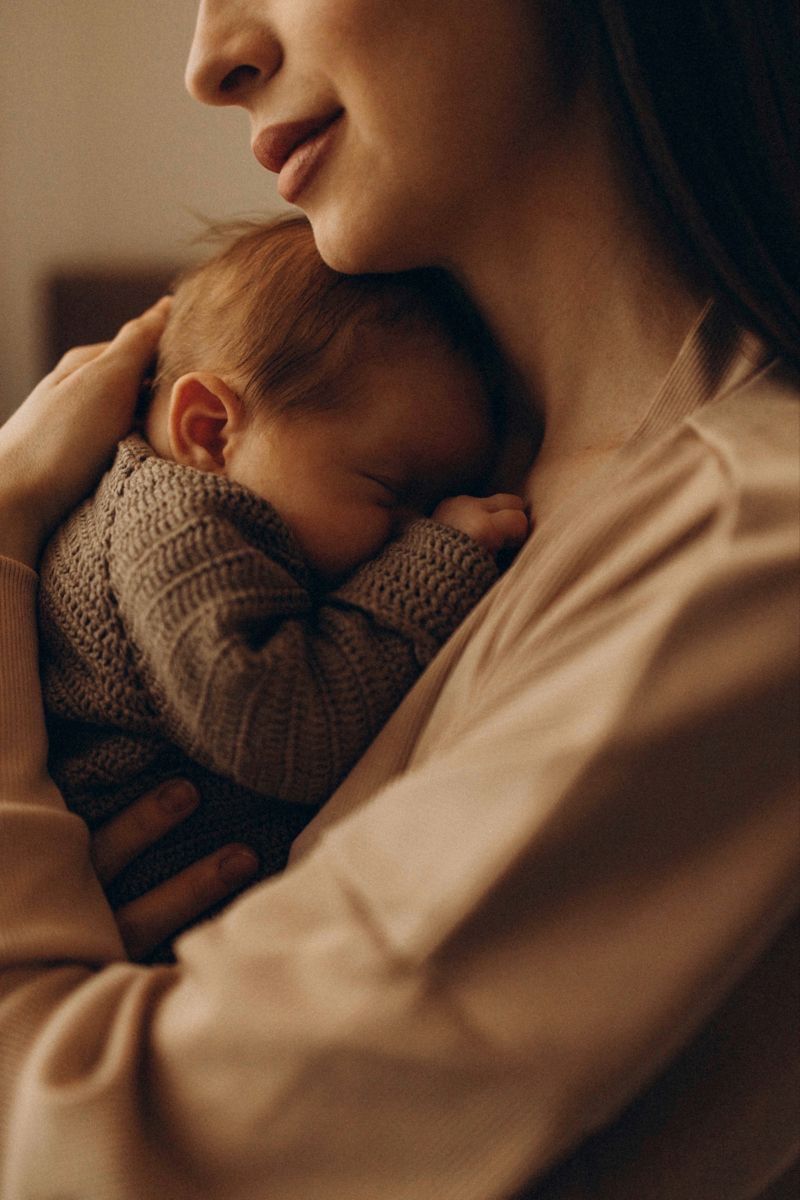 A mother holding her newborn in a warm, quiet room at a Kerala care centre